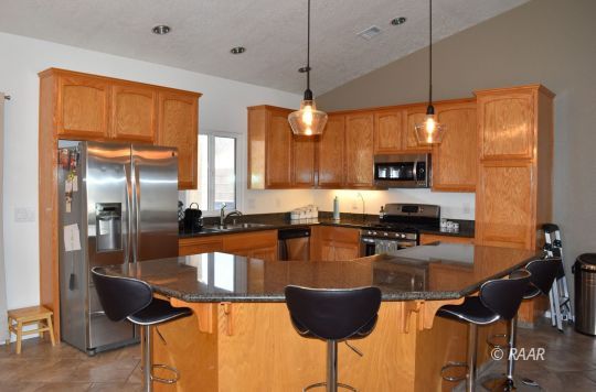 412 Abigail Street Ridgecrest, CA 93555 - Photo 5 of 14 a kitchen with stainless steel appliances granite countertop a stove a sink and a refrigerator