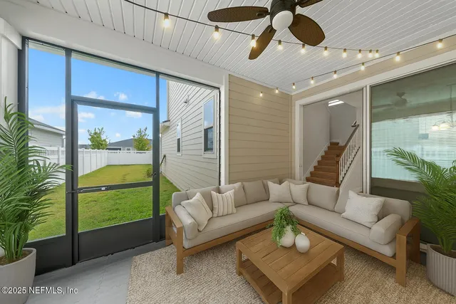a living room with furniture and a floor to ceiling window