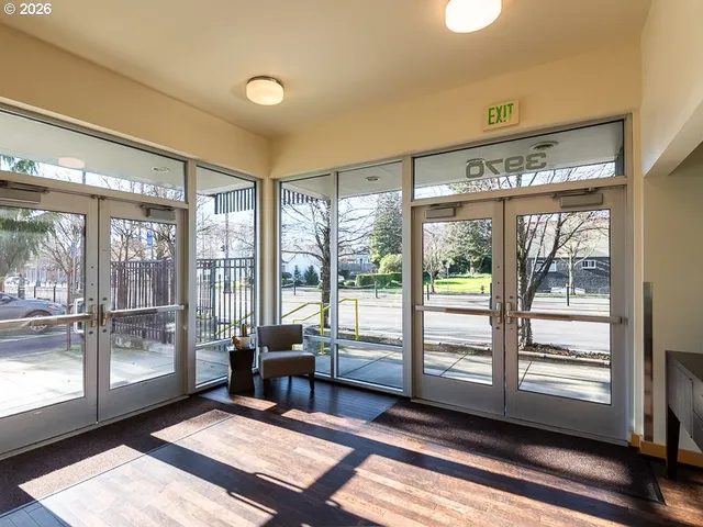 a living room with hardwood floor and large windows