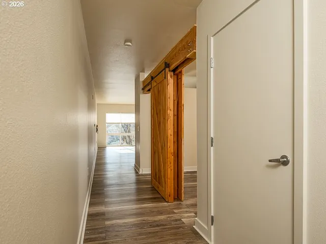 a view of a hallway with wooden floor and staircase