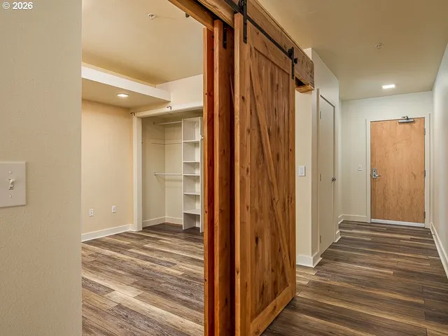a view of a hallway with wooden floor and staircase