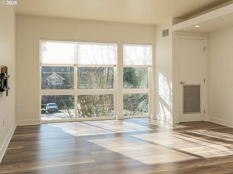 3970 North Interstate Avenue, Unit 208 Portland, OR 97227 - Photo 5 of 20 a view of an empty room with wooden floor and a window
