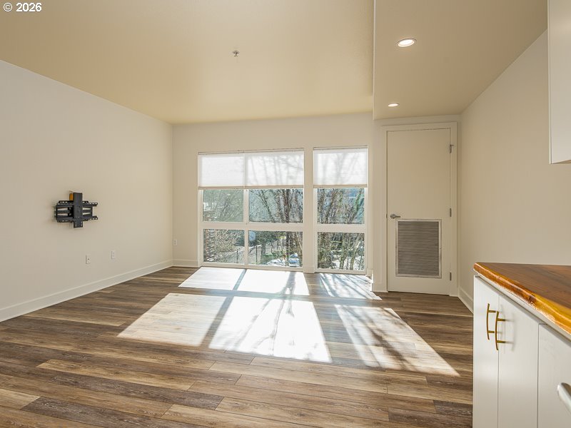 3970 North Interstate Avenue, Unit 208 Portland, OR 97227 - Photo 6 of 20 a view of an empty room with wooden floor and a window