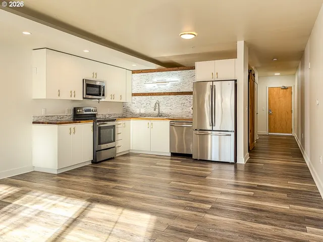 a kitchen with granite countertop a refrigerator and a stove top oven