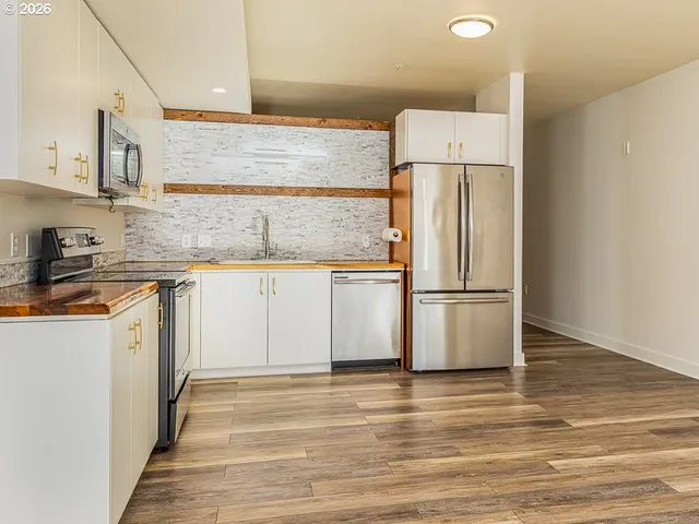 a kitchen with granite countertop a refrigerator and a sink