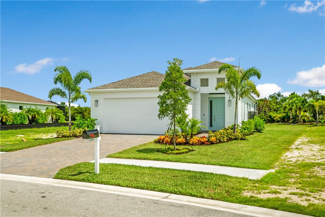 2148 Falls Manor Vero Beach, FL 32967 - Photo 2 of 25 a front view of a house with a yard and garage
