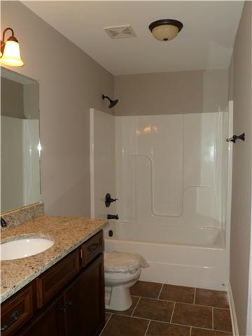 532 Halltown Road Portland, TN 37148 - Photo 14 of 15 a bathroom with a granite countertop sink a toilet and shower
