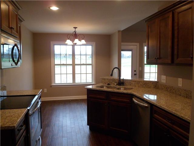 532 Halltown Road Portland, TN 37148 - Photo 9 of 15 a kitchen with granite countertop a sink a stove cabinets and wooden floor