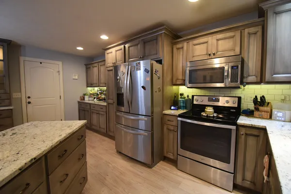 a kitchen with stainless steel appliances granite countertop a refrigerator and a sink