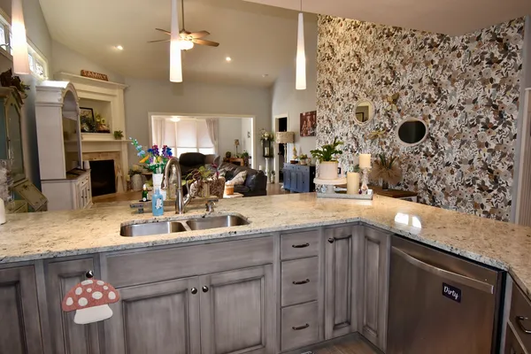 a kitchen with stainless steel appliances granite countertop a refrigerator a sink and a stove