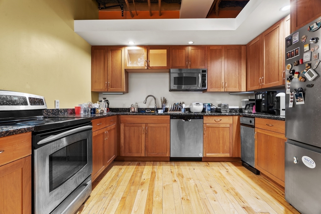 111 Beach Street, Unit 4E Boston, MA 02111 - Photo 1 of 1 a kitchen with granite countertop a stove top oven sink and cabinets