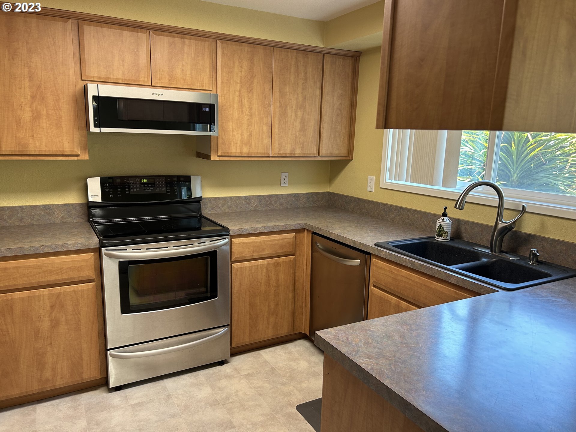 6558 Thurston Road Springfield, OR 97478 - Photo 12 of 26 a kitchen with sink a microwave a stove and cabinets