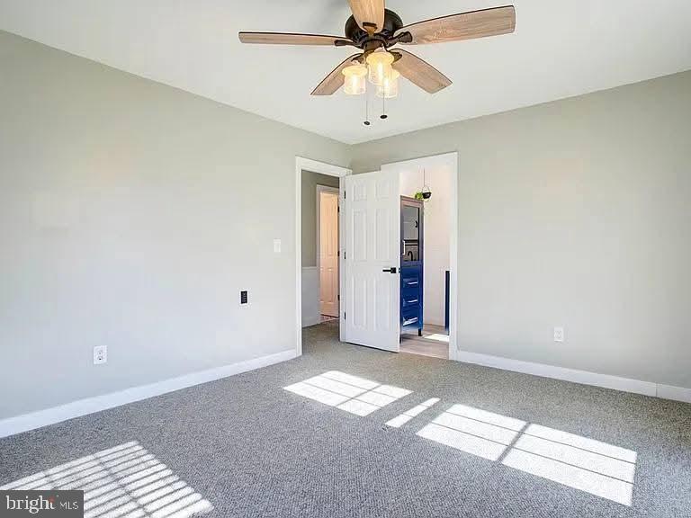 12148 Atlantic Road Temperanceville, VA 23442 - Photo 14 of 30 an empty room with chandelier fan and windows