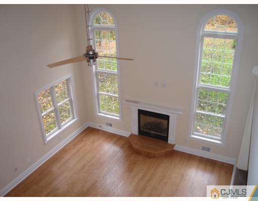 3 Fishel Road Edison, NJ 08820 - Photo 5 of 10 an empty room with wooden floor a chandelier fan and windows
