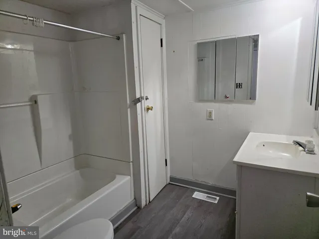 a bathroom with a tub sink and mirror