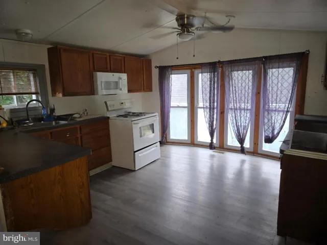 a kitchen with stainless steel appliances granite countertop a stove a sink dishwasher a refrigerator and cabinets with wooden floor