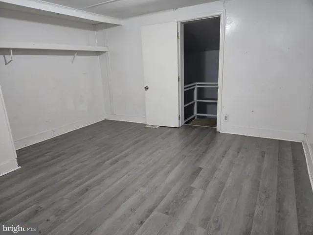 an empty room with wooden floor and closet