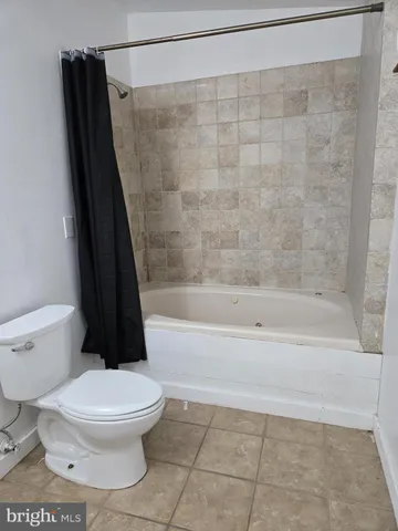 a white toilet sitting next to a bath tub and a shower