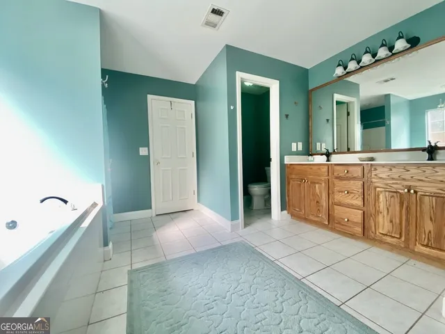 a large bathroom with a granite countertop sink and a mirror