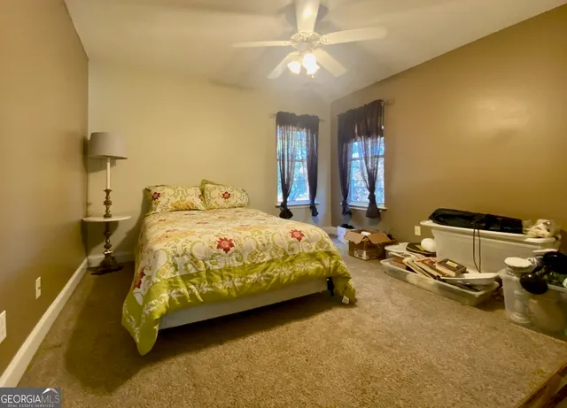 a bedroom with a bed dresser and a chandelier