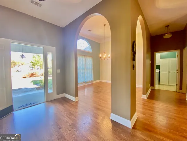 a view of a room with wooden floor mirror and windows