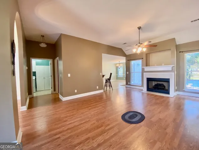 a view of a livingroom with a fireplace a chandelier and wooden floor