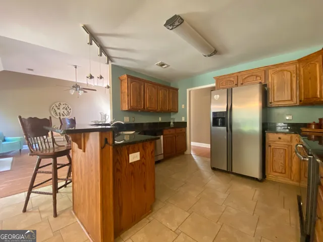 a kitchen with stainless steel appliances granite countertop a refrigerator and a stove top oven