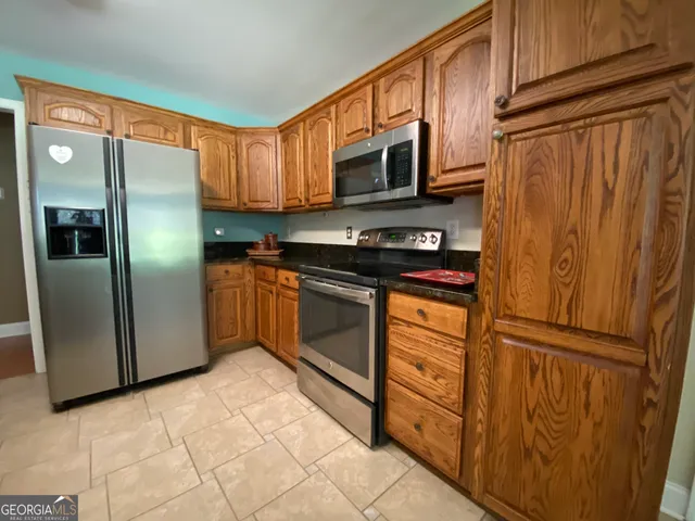 a kitchen with stainless steel appliances granite countertop a refrigerator stove and sink
