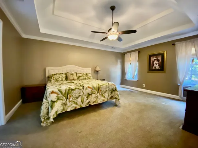 a bedroom with a bed and painting on the wall