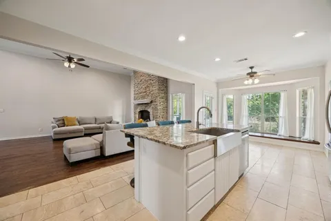 a kitchen with stainless steel appliances granite countertop a stove top oven a sink refrigerator and cabinets