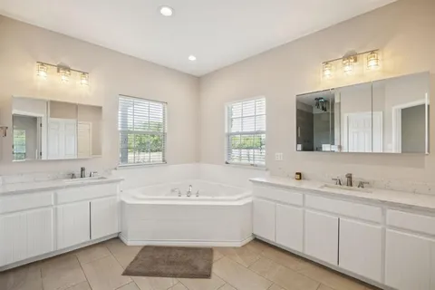 a bathroom with a tub sink and mirror