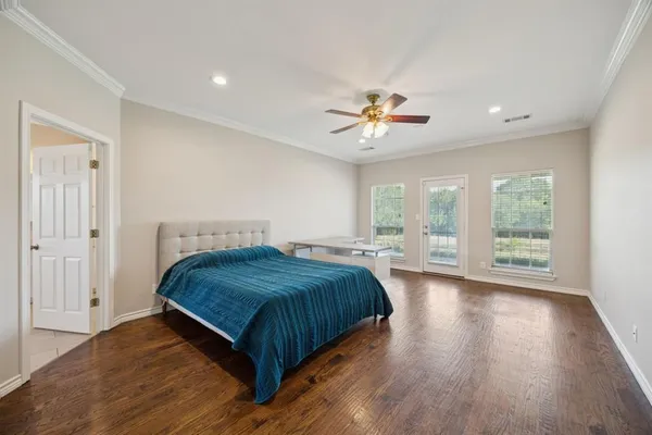 a bedroom with a large bed and a ceiling fan