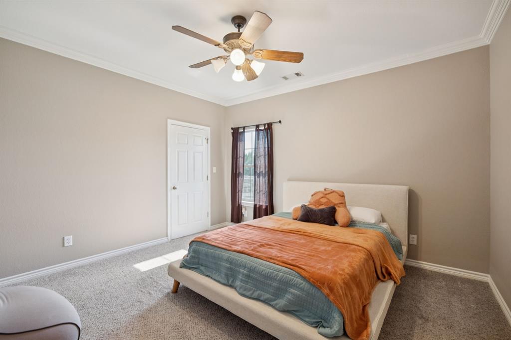 9530 County Road 581 Anna, TX 75409 - Photo 26 of 39 a bedroom with a large bed and a ceiling fan