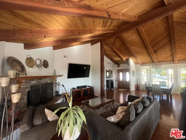 a living room with furniture kitchen view and a large window