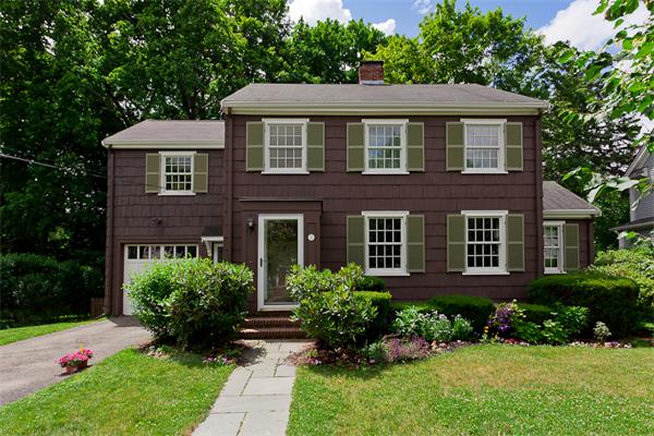 a front view of a house with a yard and trees