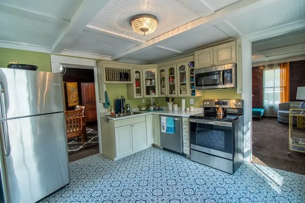 a kitchen with stainless steel appliances granite countertop a refrigerator a stove and a sink with large window