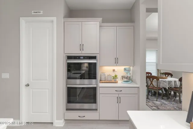 a kitchen with a dining table chairs refrigerator and microwave