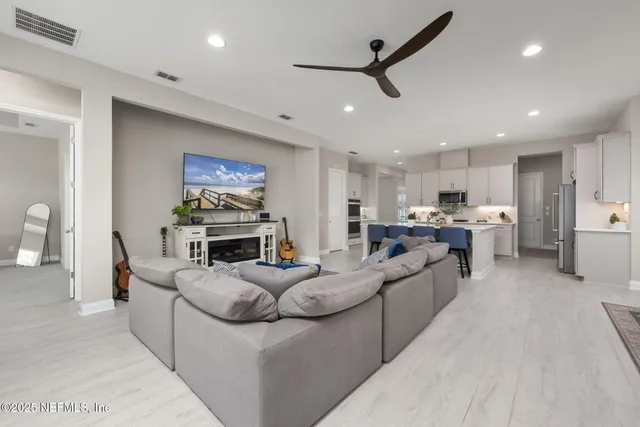 a living room with furniture and kitchen view