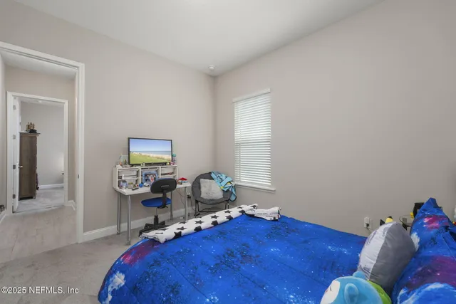 a bedroom with a bed and a painting on the wall