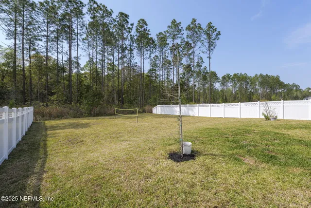 a view of a white house with a yard and plants