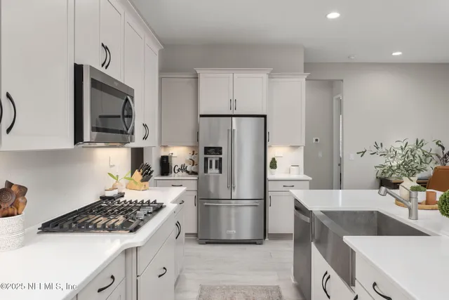 a kitchen with a refrigerator sink and cabinets