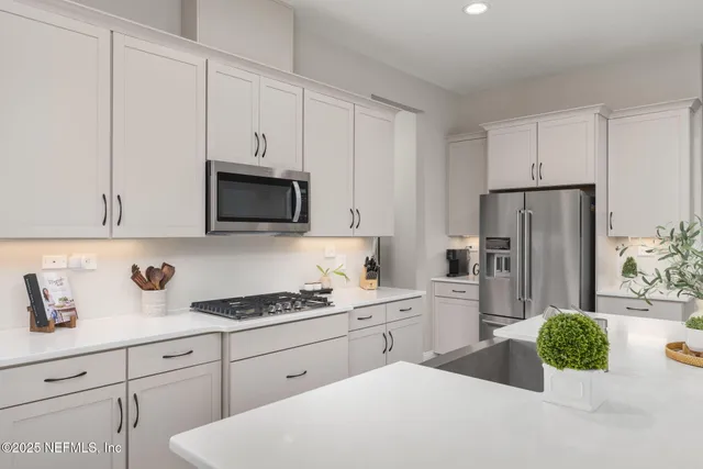 a kitchen with stainless steel appliances granite countertop a stove and white cabinets
