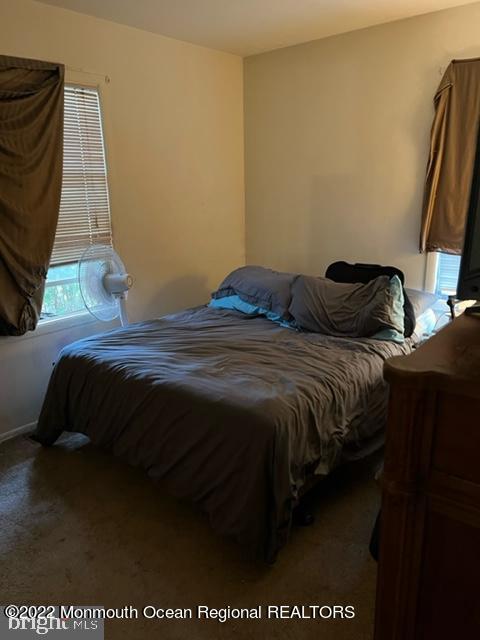 282 Privateer Road Manahawkin, NJ 08050 - Photo 9 of 18 a bed sitting in a bedroom next to a window