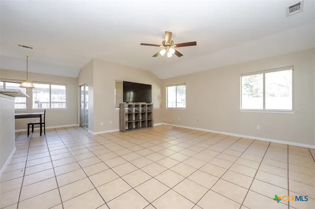 a view of an empty room with window and cabinet