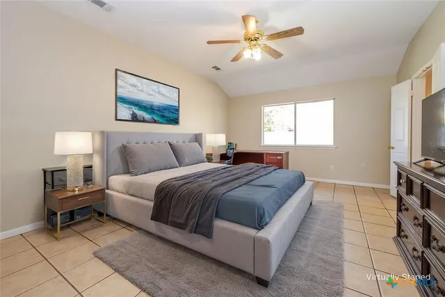 a bedroom with a bed a chandelier and a window