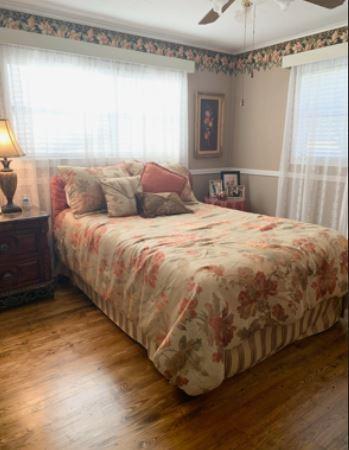 429 South Broadway Street Bells, TX 75414 - Photo 9 of 10 a large bed sitting in a bedroom next to a window and a wooden floor