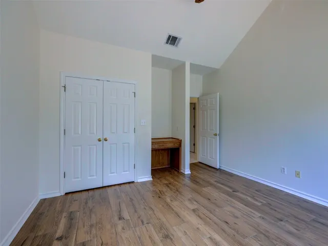a view of an empty room with wooden floor