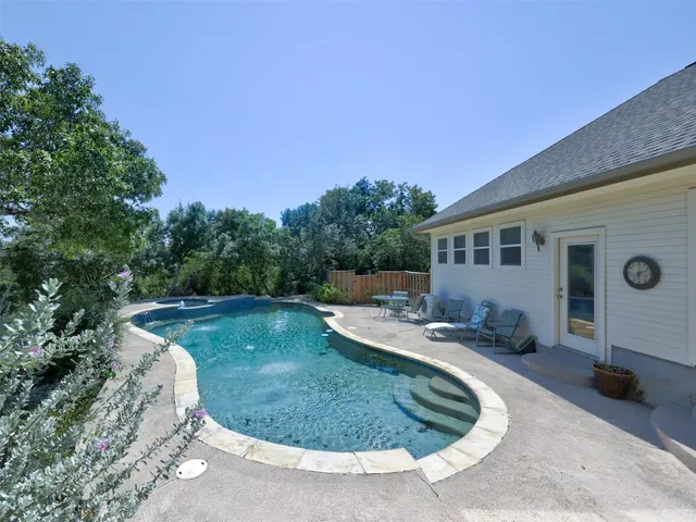 a view of a house with backyard swimming pool and sitting area