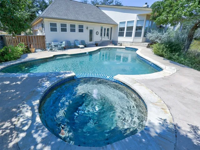 a view of a house with backyard sitting area and swimming pool