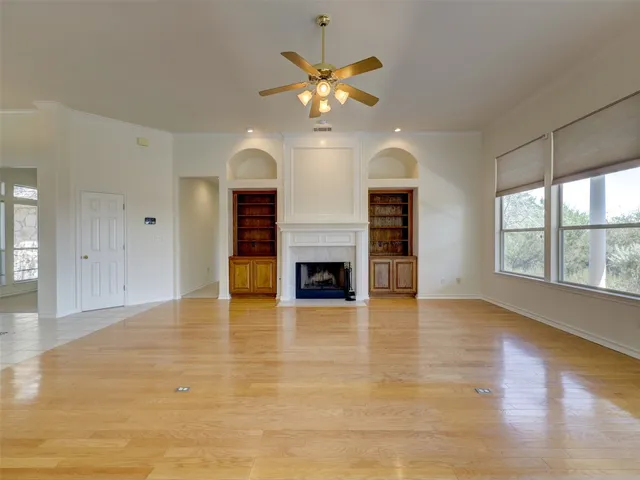 a view of an empty room with a fireplace and a window
